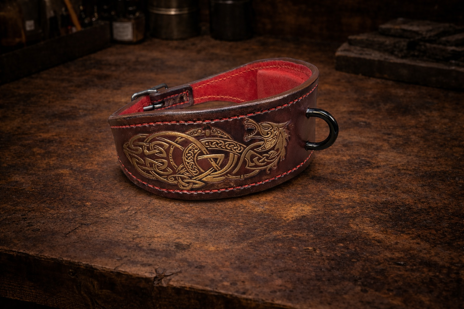 Decorative leather dog collar with intricate bronze patterns on a rustic wooden surface